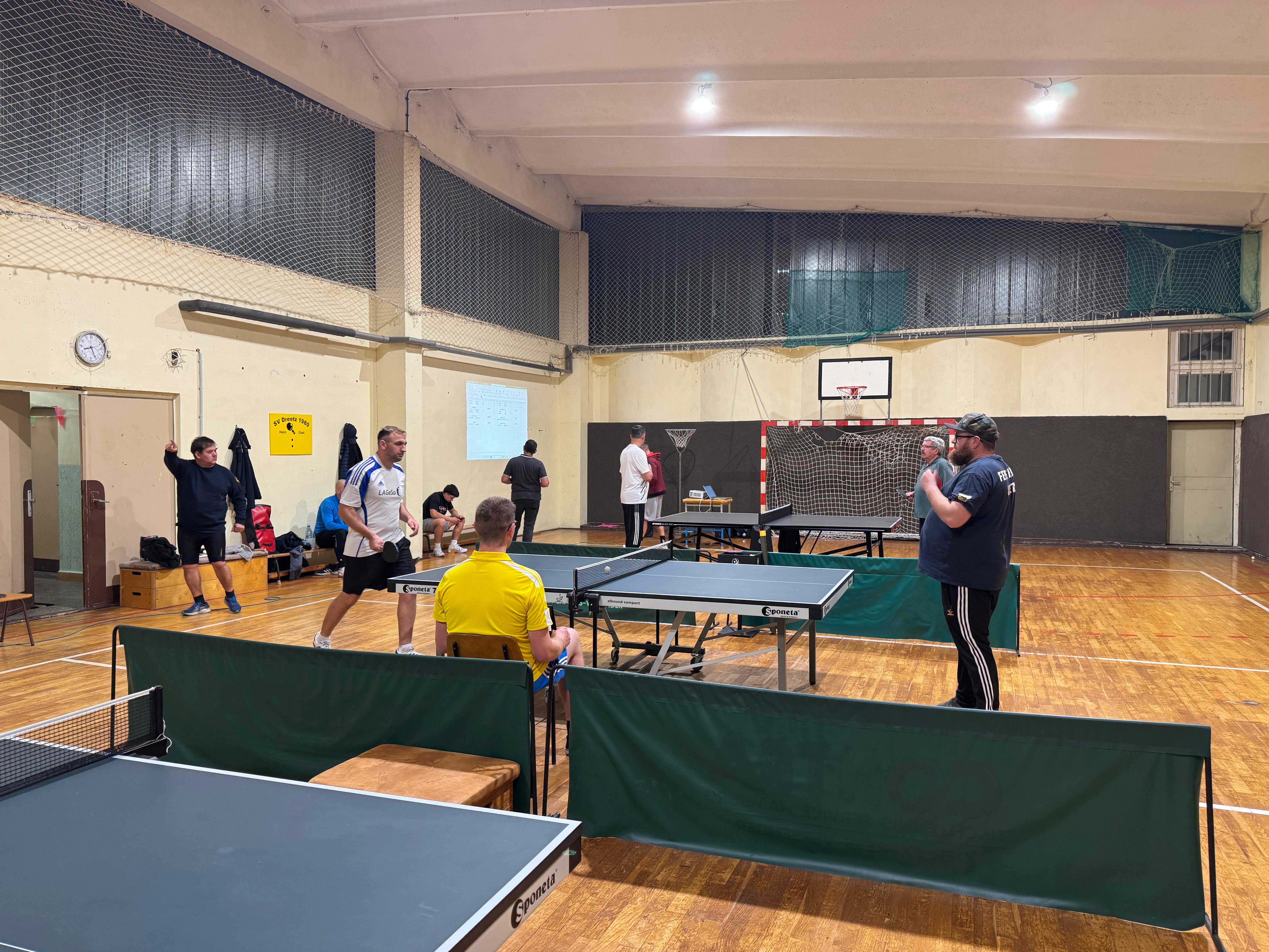 Turnhalle Dreetz, mehrere aufgebaute Tischtennisplatten; Kameraden am Spielen an den Platten